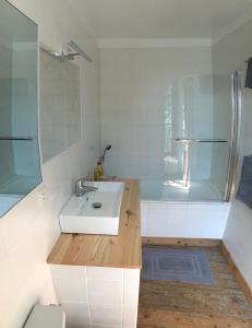 a white bathroom with a sink and a shower at Maison d'hôtes de Charme in Bayeux