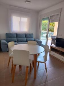 a living room with a table and chairs and a couch at Apartamento Blau Mar in Piles