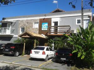 two cars parked in a parking lot in front of a building at Hotel Pousada Rio Mar in Ubatuba