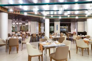un restaurante con mesas, sillas y luces en Villa del Palmar Cancun Luxury Beach Resort & Spa, en Cancún