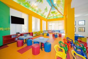 カンクンにあるVilla del Palmar Cancun Luxury Beach Resort & Spaのテーブルと椅子、薄型テレビが備わる教室です。