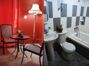 a bathroom with a sink and a toilet and a table at RB Bed and Breakfast in Kalibo