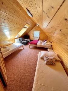 Habitación con 2 camas en una cabaña de madera en Penzion Benecko 171, en Benecko