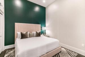 - une chambre avec un lit et un mur vert dans l'établissement The Catherine, à La Nouvelle-Orléans