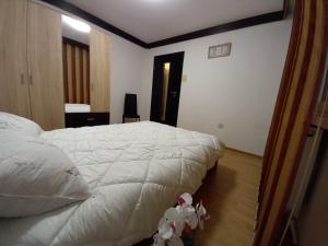 a bedroom with a white bed and a desk at ALMA Apartament in Piatra Neamţ