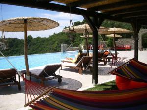 un complejo con piscina con sillas y sombrillas en Green Hill Resort en Pelekas