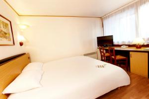 a hotel room with a white bed and a desk at Campanile Epernay - Dizy 51530 in Épernay