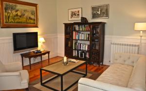 sala de estar con TV y estante de libros en Hotel Rural La Raposera, en Caravia