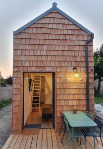 un piccolo capanno con tavolo e tavolo di TINY HOUSE Cosy 1 - Angers Green Lodge ad Angers