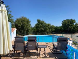 een groep stoelen naast een zwembad bij Casa do Meio- Farm house- Tavira in Tavira