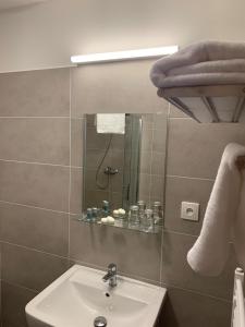 ein Bad mit einem Waschbecken, einer Dusche und einem Spiegel in der Unterkunft APARTMÁNY VILA LIBĚNA in Ostrava