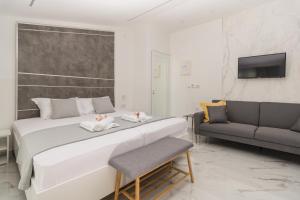 a bedroom with a large bed and a couch at Del Soll in Polychrono