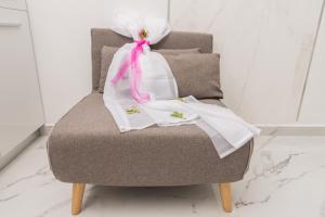 a chair with a pink ribbon and white clothes on it at Del Soll in Polychrono +57 photos