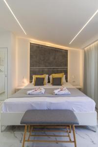 a bedroom with a large white bed with two chairs at Del Soll in Polychrono