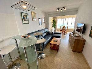 sala de estar con sofá y mesa en Apartamento Torre Levante, primera línea de playa, en Benidorm