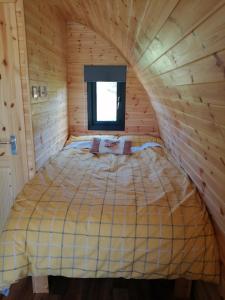 a bed in a log cabin with a window at Portnalong Pod in Port na Long