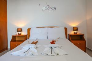una camera da letto con due asciugamani su un letto con due lampade di Antonia House a Città di Skiathos