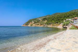 a sandy beach next to a body of water at Fotis Studios in Skopelos Town
