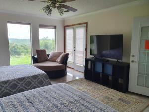 a bedroom with two beds and a flat screen tv at Hilltop Hacienda in San Marcos