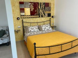 een slaapkamer met een bed met een gele sprei bij B&B Angelina in Minturno