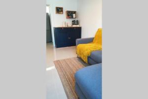 比達爾的住宿－La maison d'Amatxi, à 150m de la plage，客厅配有蓝色的沙发和黄色的毯子