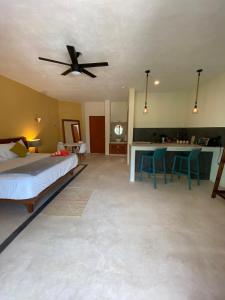1 dormitorio con 1 cama y ventilador de techo en AURORA, en Isla Holbox