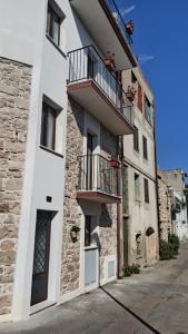 a white building with two balconies on a street at “Sa Scala” Bed&Terrace in Baunei