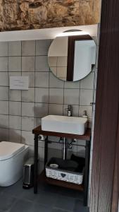 W łazience znajduje się umywalka i lustro. w obiekcie “Sa Scala” Bed&Terrace w mieście Baunei
