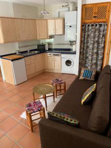 a living room with a couch and a kitchen at Acogedor Apartamento - La Alpujarra in Bubión