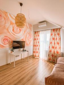 a living room with a wall mural of roses at Ranczo Na Sówce in Ciechanowiec