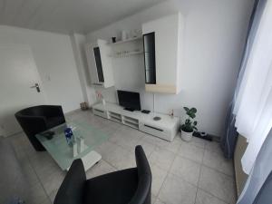 a living room with a glass table and black chairs at FEWO BEI LEHMANNS in Werl