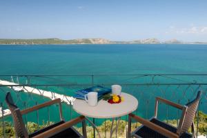 un tavolo e sedie su un balcone con vista sull'oceano di Tina's House a Pylos