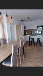 une cuisine avec une grande table et des chaises en bois dans l'établissement Apartament Nad Jeziorem Ewa, à Nadole