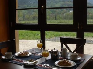 a table with plates of food and glasses of orange juice at Hotel San Francisco Rural in Aballe
