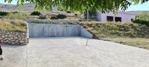a concrete patio in front of a stone wall at Apartment Twins in Pag