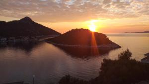 einen Sonnenuntergang über einer kleinen Insel im Wasser in der Unterkunft APARTMAN KARLA in Lastovo