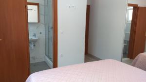 Schlafzimmer mit einem Bett, einer Dusche und einem Waschbecken in der Unterkunft APARTMAN KARLA in Lastovo
