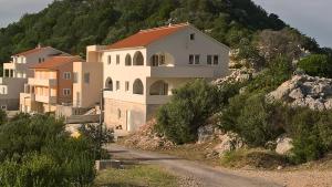 eine Gruppe von Häusern auf einem Hügel neben einer Straße in der Unterkunft APARTMAN KARLA in Lastovo
