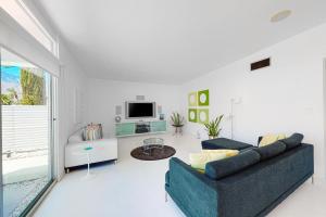 a living room with a couch and a tv at Poolside Modern Wexler Permit# 1261 in Palm Springs