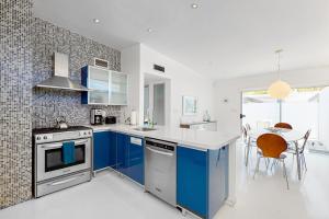 una cocina con armarios azules y una mesa con sillas en Poolside Modern Wexler Permit# 1261 en Palm Springs