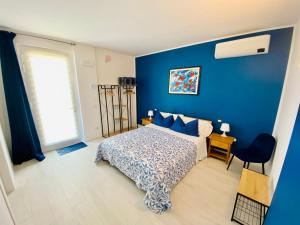 Dormitorio azul con cama y pared azul en I Broletti del Garda en Pacengo di Lazise