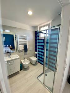 La salle de bains est pourvue de toilettes, d'un lavabo et d'une douche. dans l'établissement I Broletti del Garda, à Pacengo di Lazise
