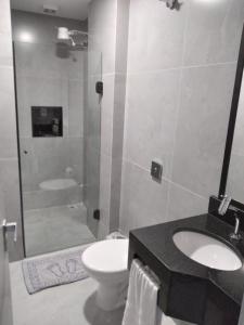 a bathroom with a toilet and a sink and a shower at Hotel Mamma Mia in Aparecida +17 photos