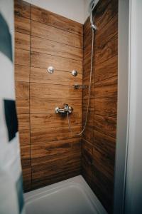 a bathroom with a shower with a wooden wall at Restoran sa prenoćištem Gornjak in Krepoljin