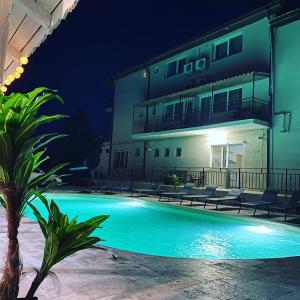 Una piscina frente a un edificio por la noche. en Vila Dedy, en Costinesti