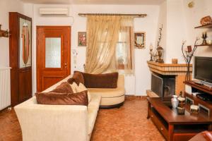 un soggiorno con divano e camino di Antonia House a Città di Skiathos