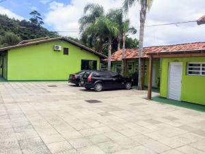 un coche aparcado en un estacionamiento frente a una casa en Pousada Morada do Sol, en Florianópolis