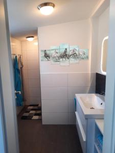 La salle de bains blanche est pourvue d'un lavabo et d'un miroir. dans l'établissement Ferienhaus auf dem Lusitanohof Jäger, à Fürth