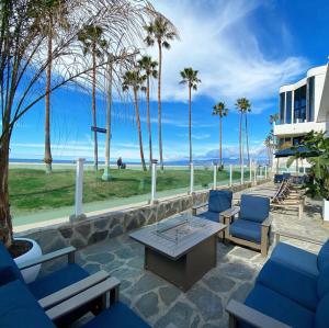 a patio with blue chairs and a table and palm trees at Venice on the Beach Hotel in Los Angeles