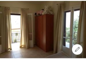 um quarto com um armário e uma varanda com janelas em Efi Loutses em Anapaftíria